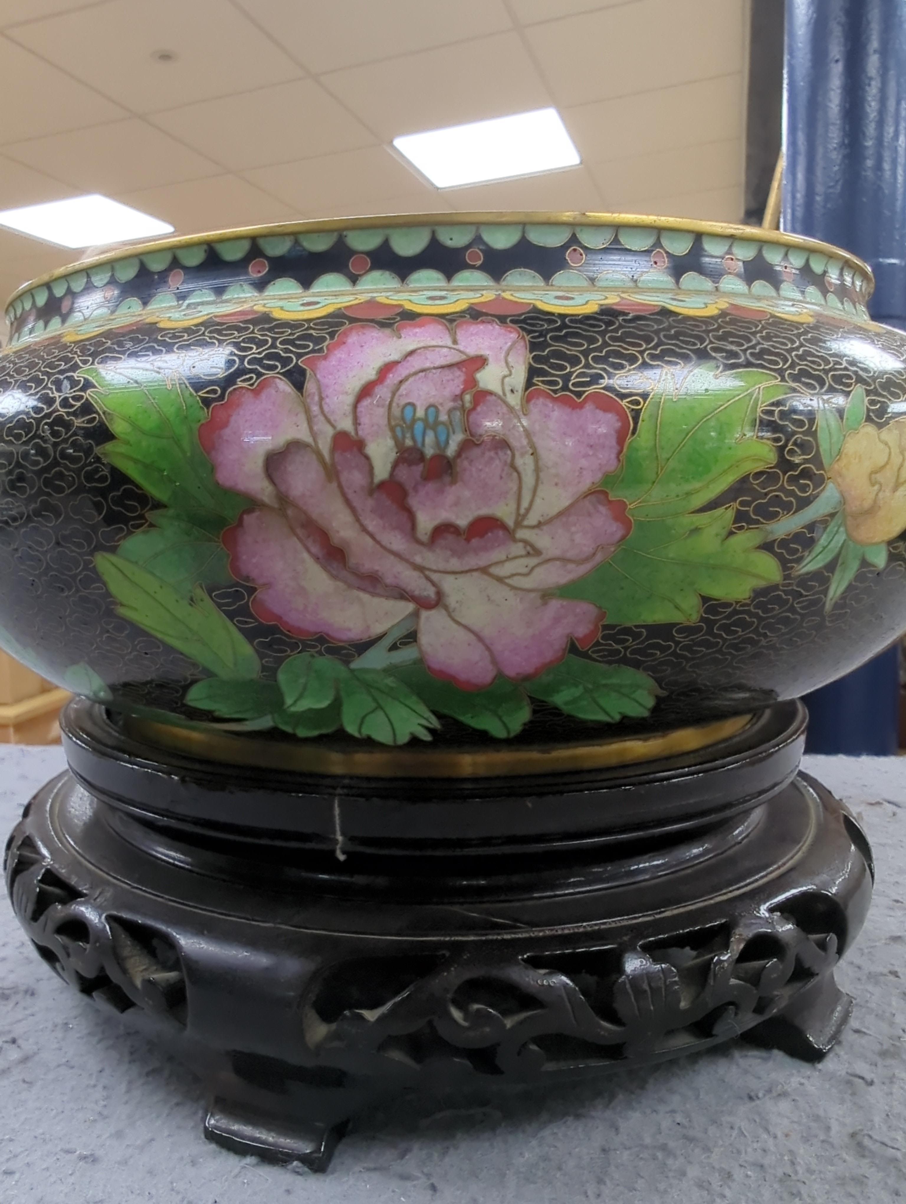 A Chinese cloisonné enamel three footed vase and cover together with a censer and cover, each raised on hardwood stands, the largest 26cm in diameter